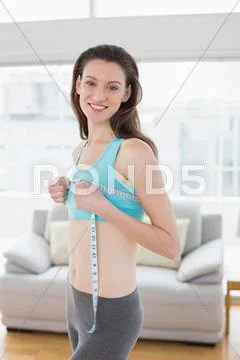 Woman in sportswear measuring chest in fitness studio Stock Photos