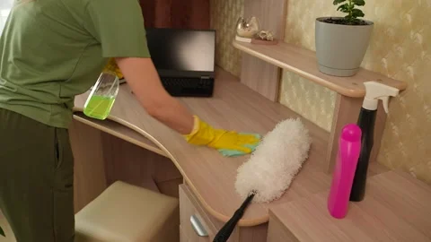 A woman is spraying cleaning solution onto the surface of the table and wiping 库存影片 311051022