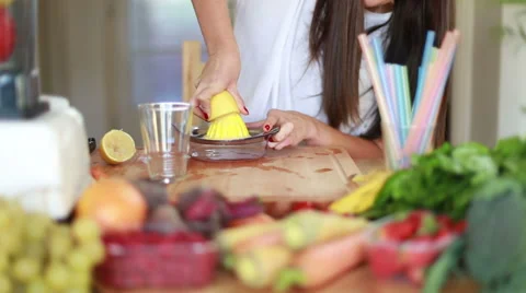 Woman squeezing half a lemon on a squeezer Stock Footage 59541140
