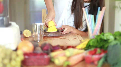 Woman squeezing half a lemon on a squeezer Stock Footage 59541145