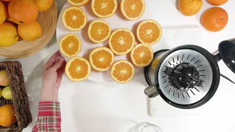 Woman squeezing oranges using electric juicer. Close up on white background,loop Stock Footage 135406070