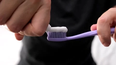 Woman squeezing toothpaste on a toothbrush close up Stock Footage 292306095