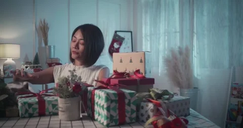 Woman stack of decorated present boxes and lovely cat to celebrate holiday Stock Footage 256385837