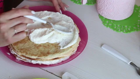 The woman is stacking the cake layers one on top of the other. Lubricates the Stock Footage 156443824