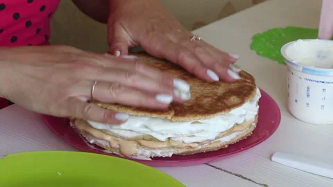 The woman is stacking the cake layers one on top of the other. Greases the ca Stock Footage 156443860
