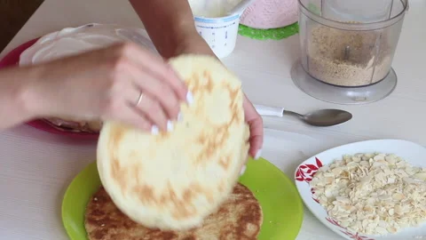 The woman is stacking the cake layers one on top of the other. Greases the ca Stock Footage 156443881