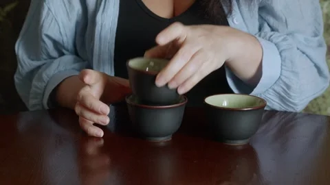 Woman stacking ceramic cups on table, calm domestic routine Stock Footage 320738022