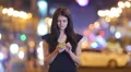 The woman stand, smile and type in the phone by city bokeh background 4k or 4k+ Resolution