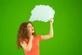 The woman stand with a virtual dialog on the green background Photo