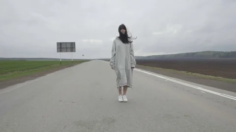 Woman standing on empty road 库存影片 75652837