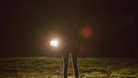 Woman Standing in Front of Car Headlight... | Stock Video | Pond5