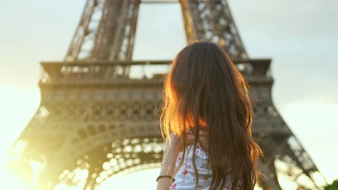 Woman standing in front of Eiffel Tower at sunset in Paris Stock Footage 313796614