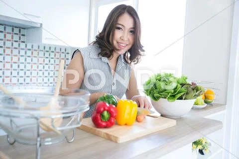 Woman standing at the kitchen counter Stock Photos