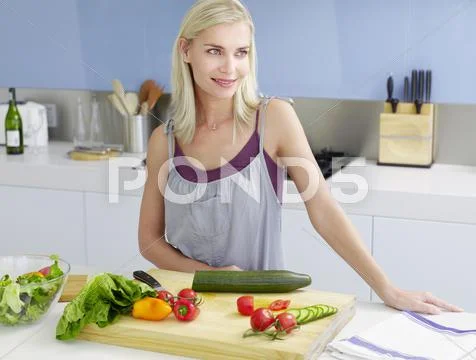 Woman Standing At Kitchen Counter Stock Photos