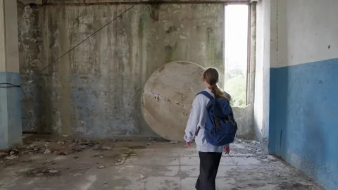 Woman standing before massive circular structure in abandoned industrial Stock-Footage 342087665