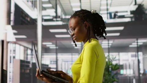 Woman standing in office, fixing coding issues using laptop Stock Footage 318159439