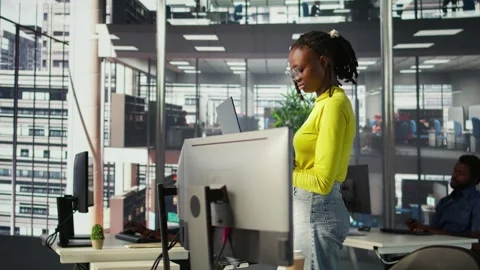 Woman standing in office, fixing coding issues using laptop Stock Footage 318160995