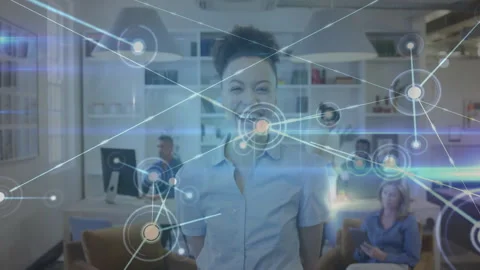 Woman standing in office, glowing node initiating network animation showing 스톡 동영상 312758281
