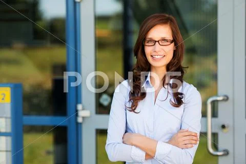 Woman standing outside her house and smiling Stock-Fotos