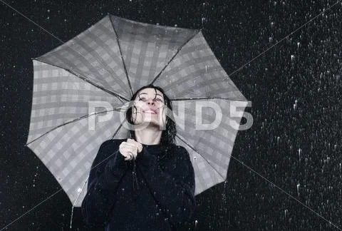 Woman Standing In Rain, Holding Umbrella.