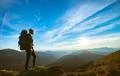 The woman standing on the rock with a picturesque sunset Photo