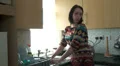 Woman standing at sink talking to someone out of shot HD Footage