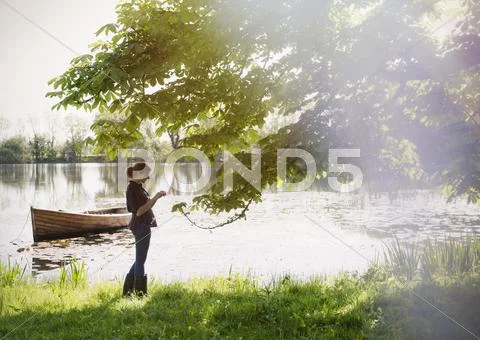 Woman standing at sunny idyllic lakeside Stock Photos
