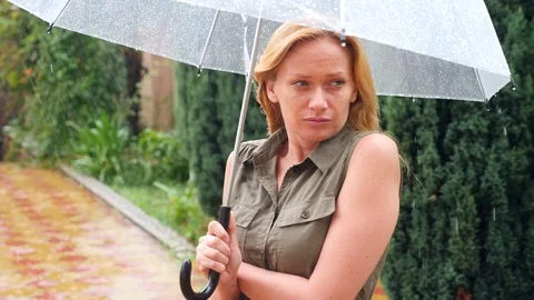 A woman is standing under an umbrella. Summer torrential downpour. 4k, slow Stock Footage