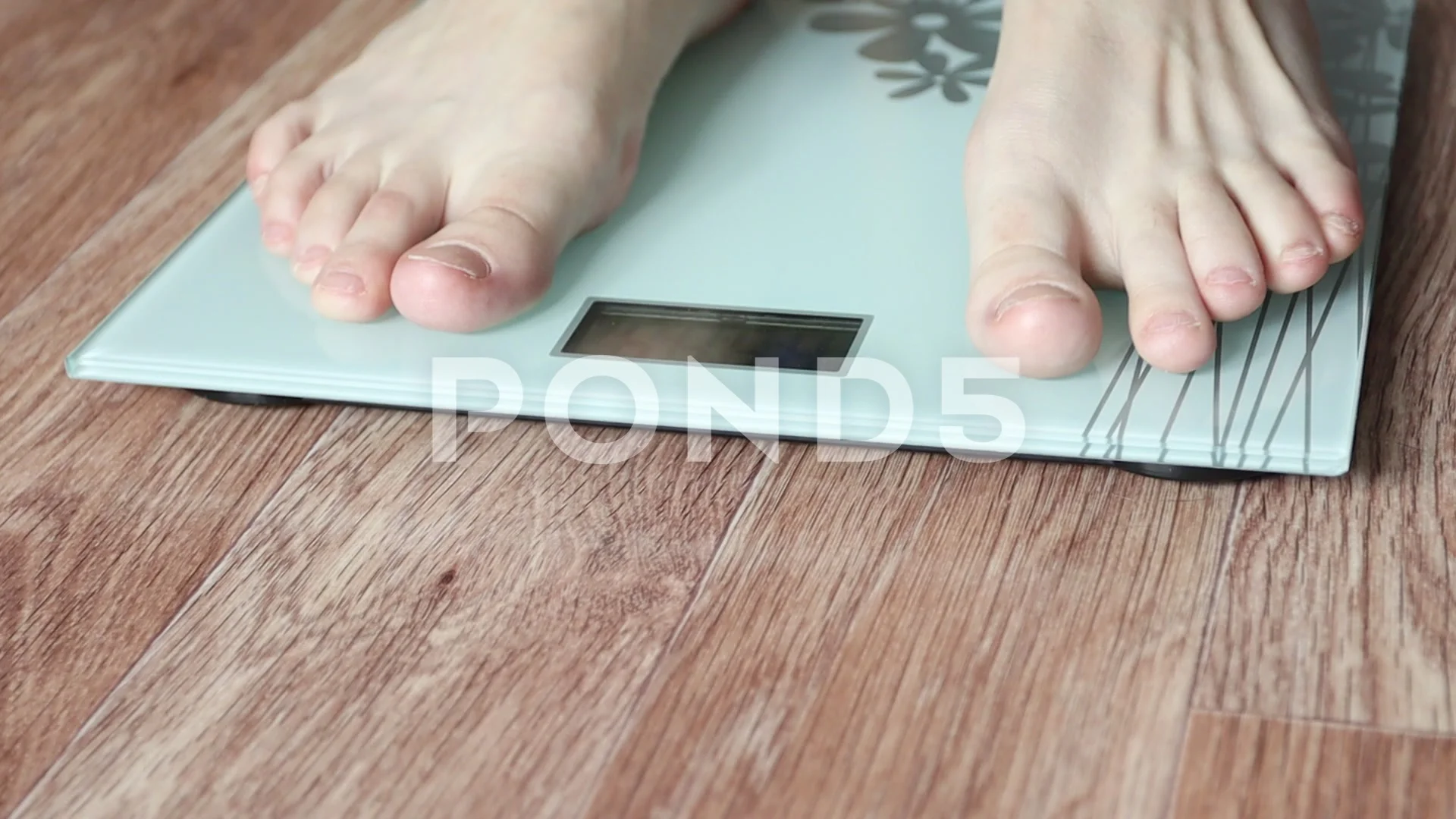 elderly woman standing barefoot on a bathroom scale and measuring