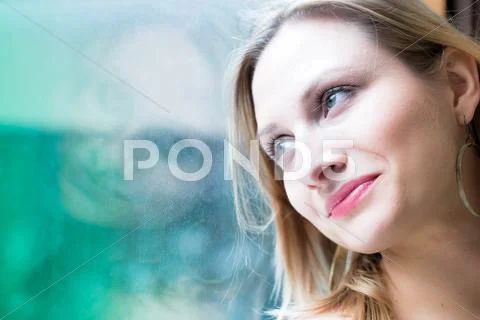 Woman standing by a window looking outside Stock-Fotos