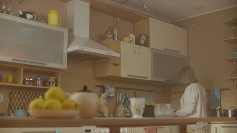 Woman stands in the kitchen. Old lady cooking in a nice kichen Stock Footage
