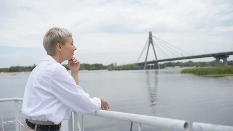 Woman stands on the pier and looks at the bridge Stock Footage