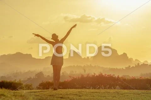 Woman stands on the sunset the beach vertical Stock Photos