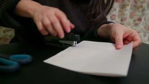 Woman Stapling Documents on Black Desk Stock Footage 332672983