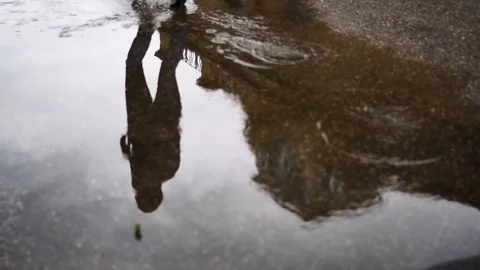 Woman stepped on a reflection in a puddle day Stock Footage 112004596