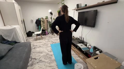 Woman stepping forward on yoga mat in living room during workout, leg exercise, Stock Footage 335645853