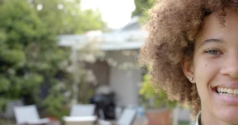 Woman is stepping into frame from right on backyard patio, smiling and laughing Stock Footage 344326557