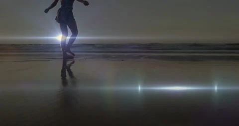 Woman stepping on wet sand causing reflection and flare, pausing arms out Stock Footage 331635043
