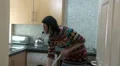Woman stops sweeping to answer phone HD Footage