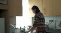 Woman stops washing up takes a cell phone call HD Footage