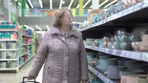 A woman in a store examines tableware for the kitchen Stock Footage 217441431