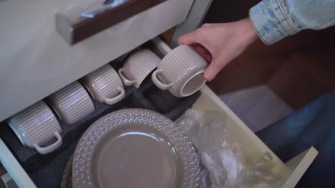 Woman storing kitchenware in a camper van drawer Stock Footage 340262709