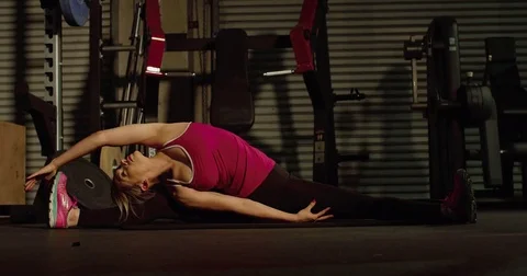 A woman stretches to the side while doing the splits Stock Footage 83327804