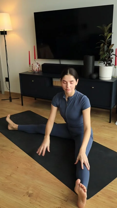 Woman stretching hamstrings and side body in half split pose Stock Footage 322163843