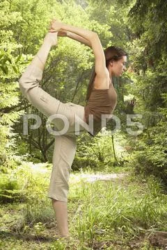 Woman stretching leg behind back Stock Photos