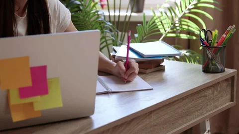 Woman student scribbles notes while reading article in library Stock Footage 300382969