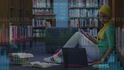 Woman student studying in library tapping laptop flipping tablet while charts Stock Footage 330756390