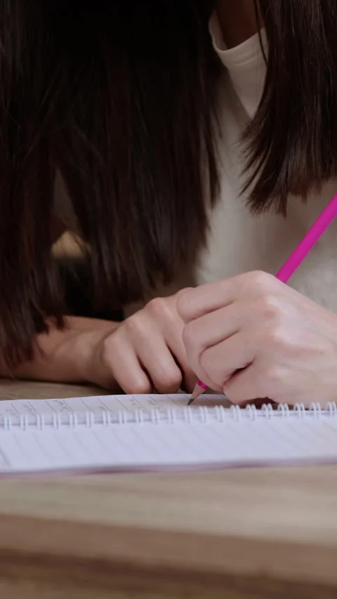 Woman student takes notes while reading online scholarly article on laptop. Video stock 305407130