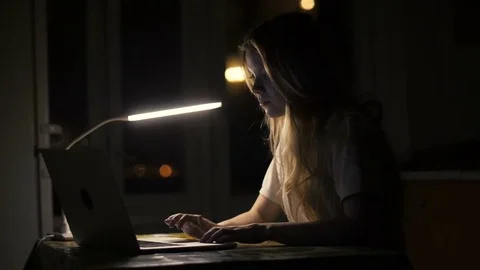 Woman student using laptop computer for online education in dark room Stock Footage 85215804