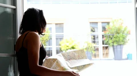 Woman studying map at the open window Stock Footage 51935203